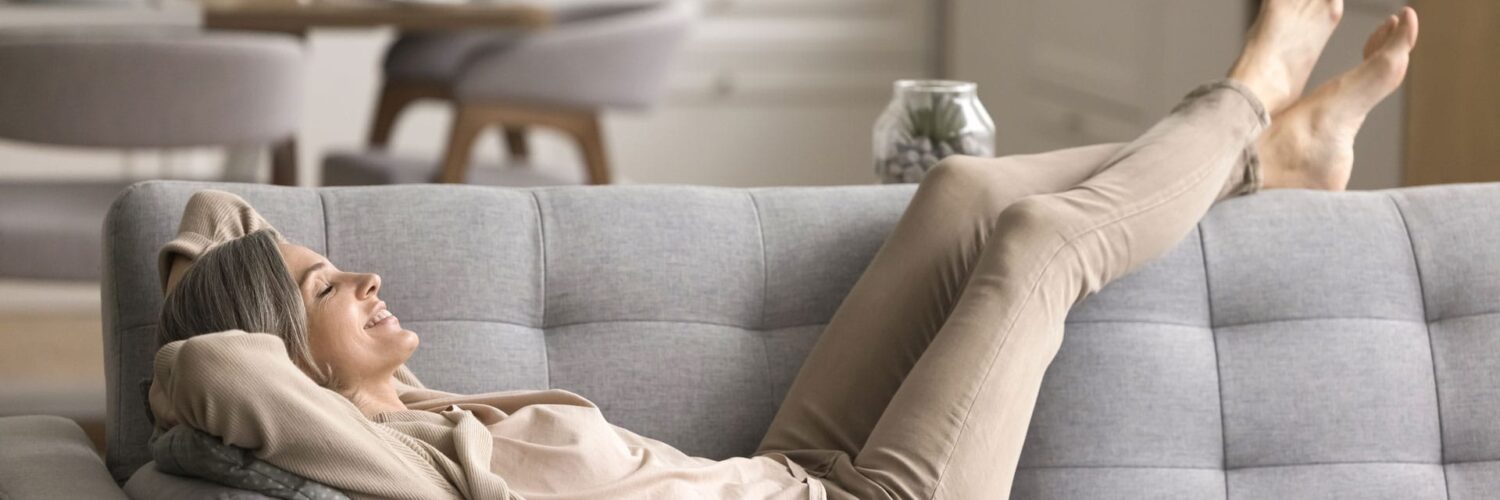 Mkc Wealth Happy Woman Lying Sofa thinking about 'what is a protected minimum pension age'